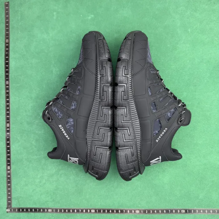 Real W2C warehouse QC photo: a pair of shoes on a green background, ruler along the left and bottom edges, sole tread and branding clearly visible