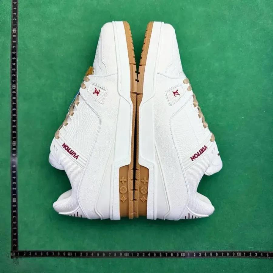 Real W2C Shoes-QC warehouse photo: a pair of shoes on a green background with a metal ruler along the left and bottom edges for scale